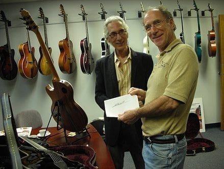 Pat Martino signs his name with Bob Benedetto. (Courtesy Benedetto Guitars)