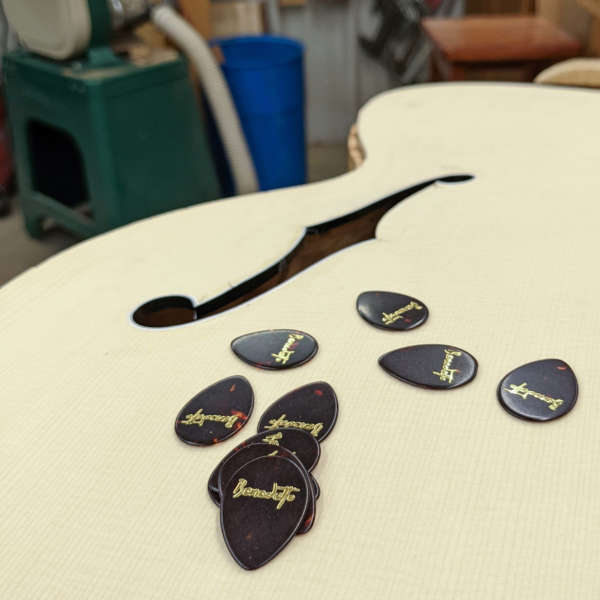Benedetto Guitar picks resting on unfinished guitar body