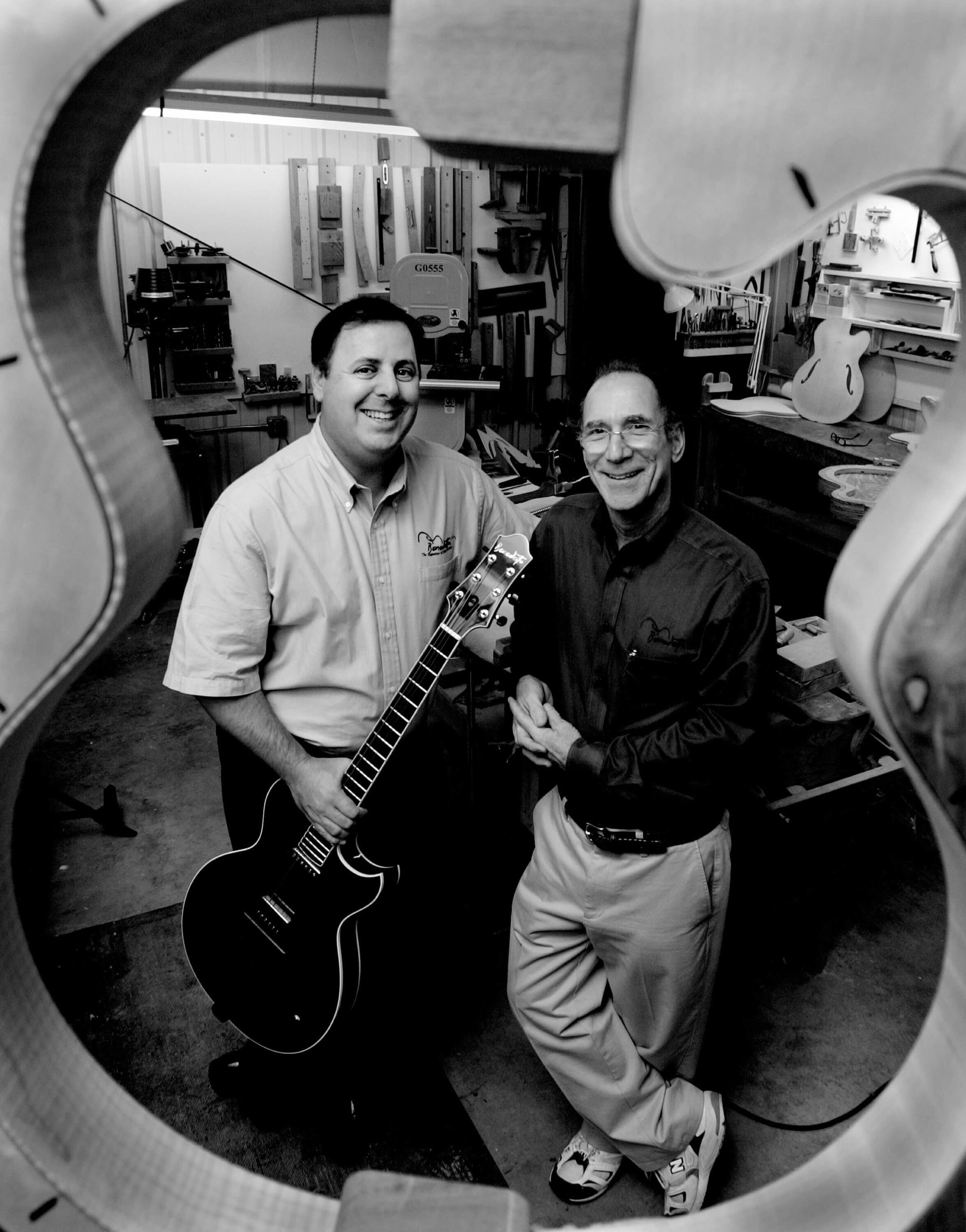Howard Paul and Bob Benedetto in shop shot through a guitar shape in black and white