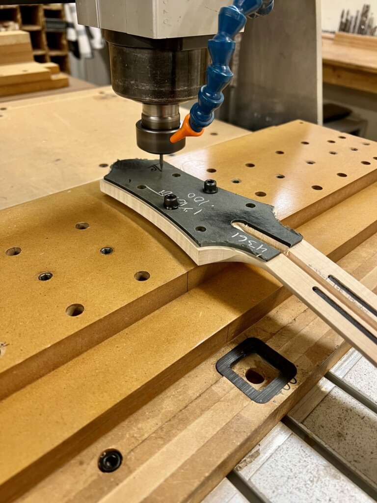 A Benedetto logo being carved into the headstock