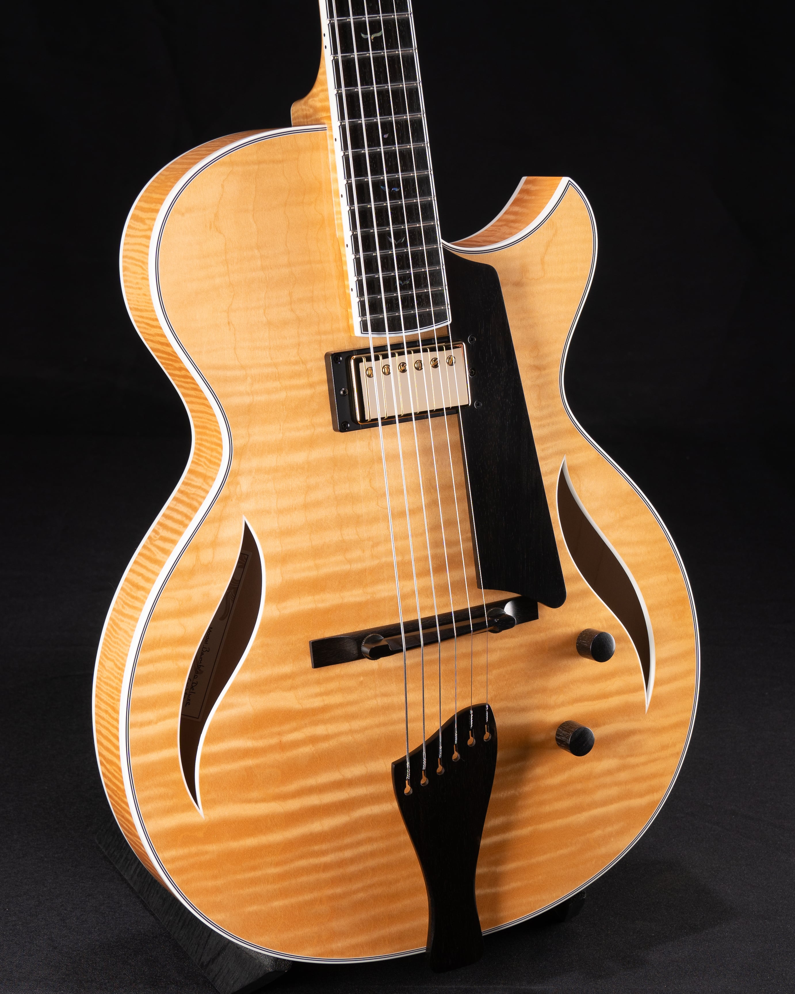 Custom ordered Benedetto Deluxe jazz guitar with Honeyblonde finish, showcasing elegant curves, intricate wood grain, and detailed craftsmanship.