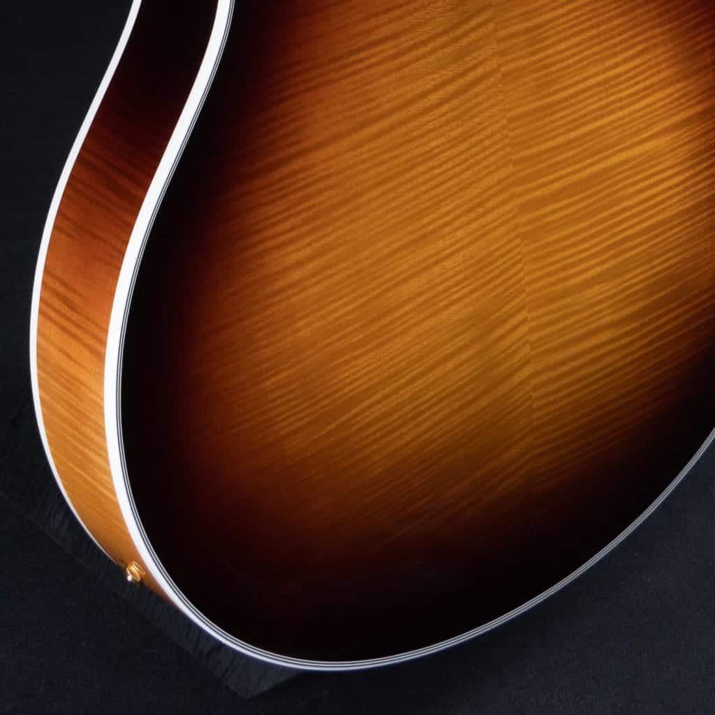 High-resolution rear view of a Benedetto 16-B archtop guitar showcasing the deep figuring of a bookmatched flamed maple back plate under a sunburst lacquer finish.